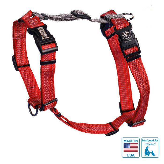 A red dog harness with black accents and reflective stitching, featuring multiple adjustment points and a label indicating 'Made in USA'.