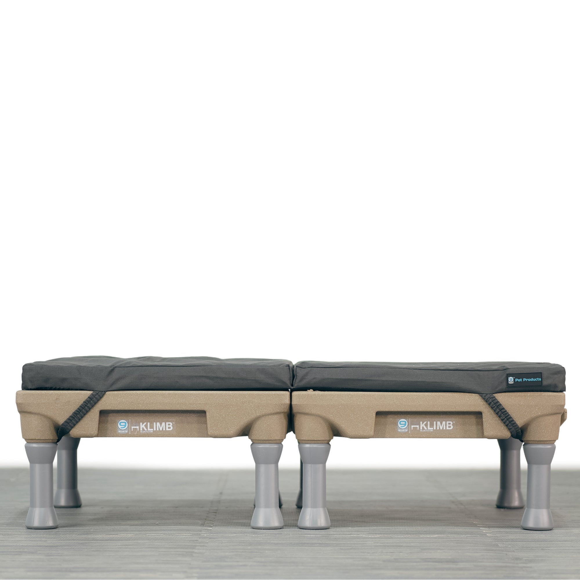 A large, grey, durable dog bed with water-resistant properties, featuring built-in carrying handles and designed to fit on top of two Klimbs.
